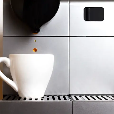 Machine à expresso argentée et tasse blanche