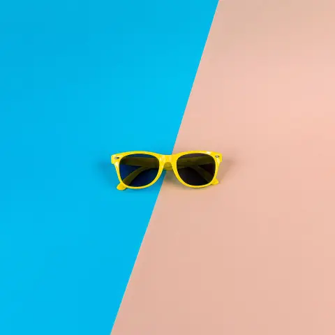 Lunettes de soleil jaunes sur fond bleu et rose