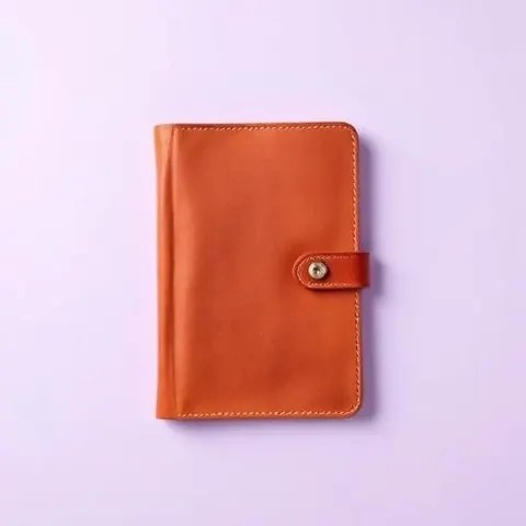 Carnet en cuir orange sur fond lavande